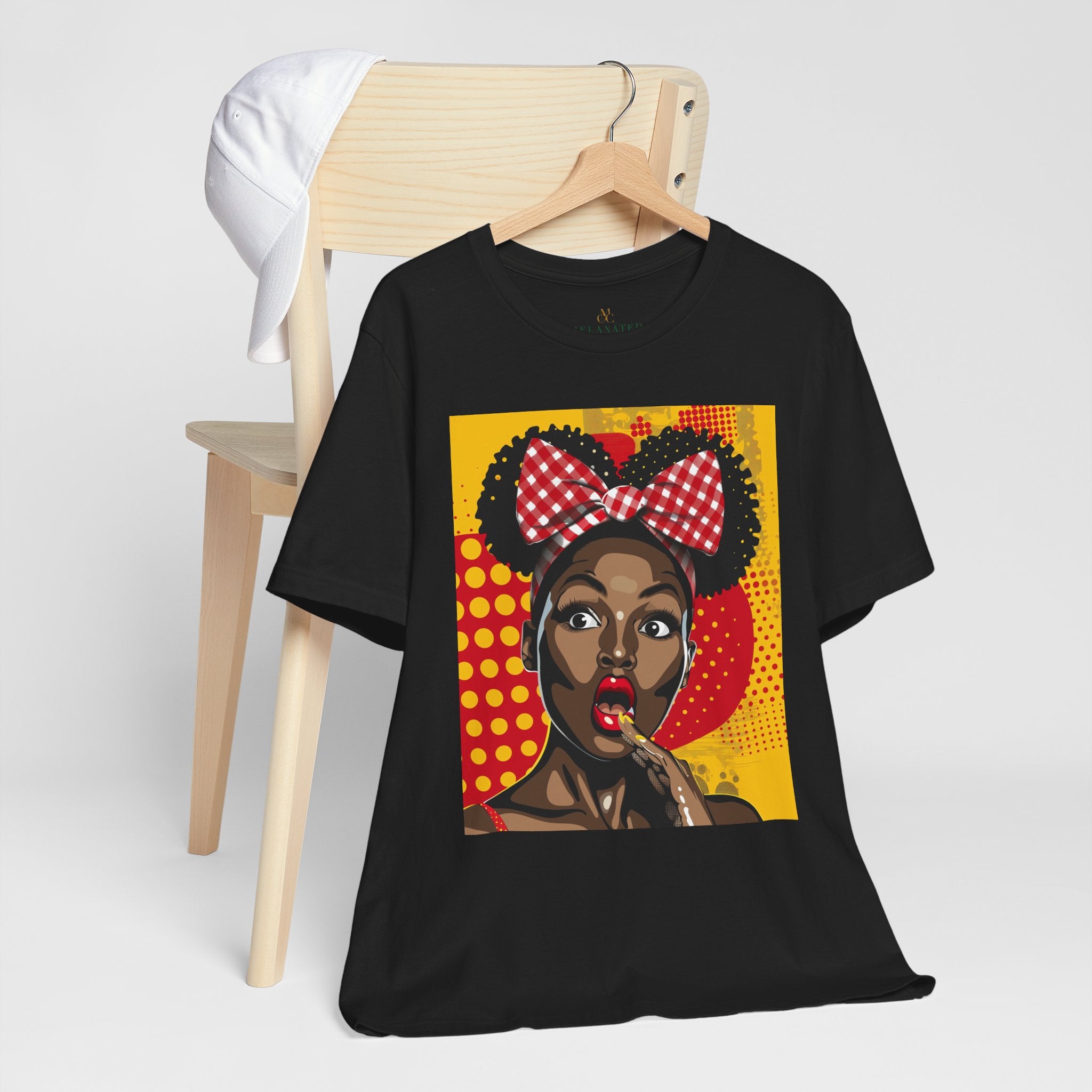 Black Girl Shocked Look Tee Shirt featuring a cartoon-style pop art illustration of a Black woman with natural hair and a red polka-dotted hair bow. Afrocentric graphic tee celebrating Black Girl Magic and expressive streetwear style.