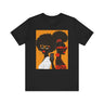 They Not Like Us Tee Shirt featuring two Black women in silhouette wearing high-fashion eyewear, holding a cell phone with the phrase "They Not Like Us" on an orange background – Afrocentric unisex apparel.