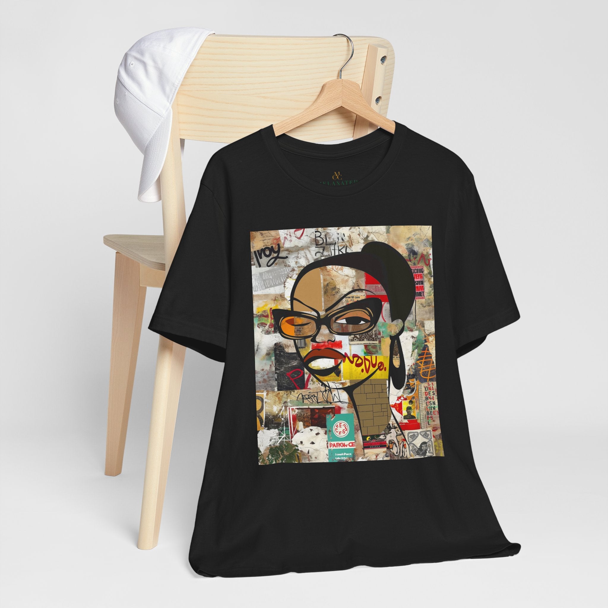 Graphic tee featuring an abstract cartoon-style illustration of a confident Black woman with stylish black-framed eyeglasses and a one-eyed inquisitive stare. The design has a bold, graffiti-inspired look that celebrates Black girl magic, attitude, and self-expression.