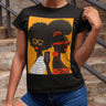 They Not Like Us Tee Shirt featuring two Black women in silhouette wearing high-fashion eyewear, holding a cell phone with the phrase "They Not Like Us" on an orange background – Afrocentric unisex apparel.