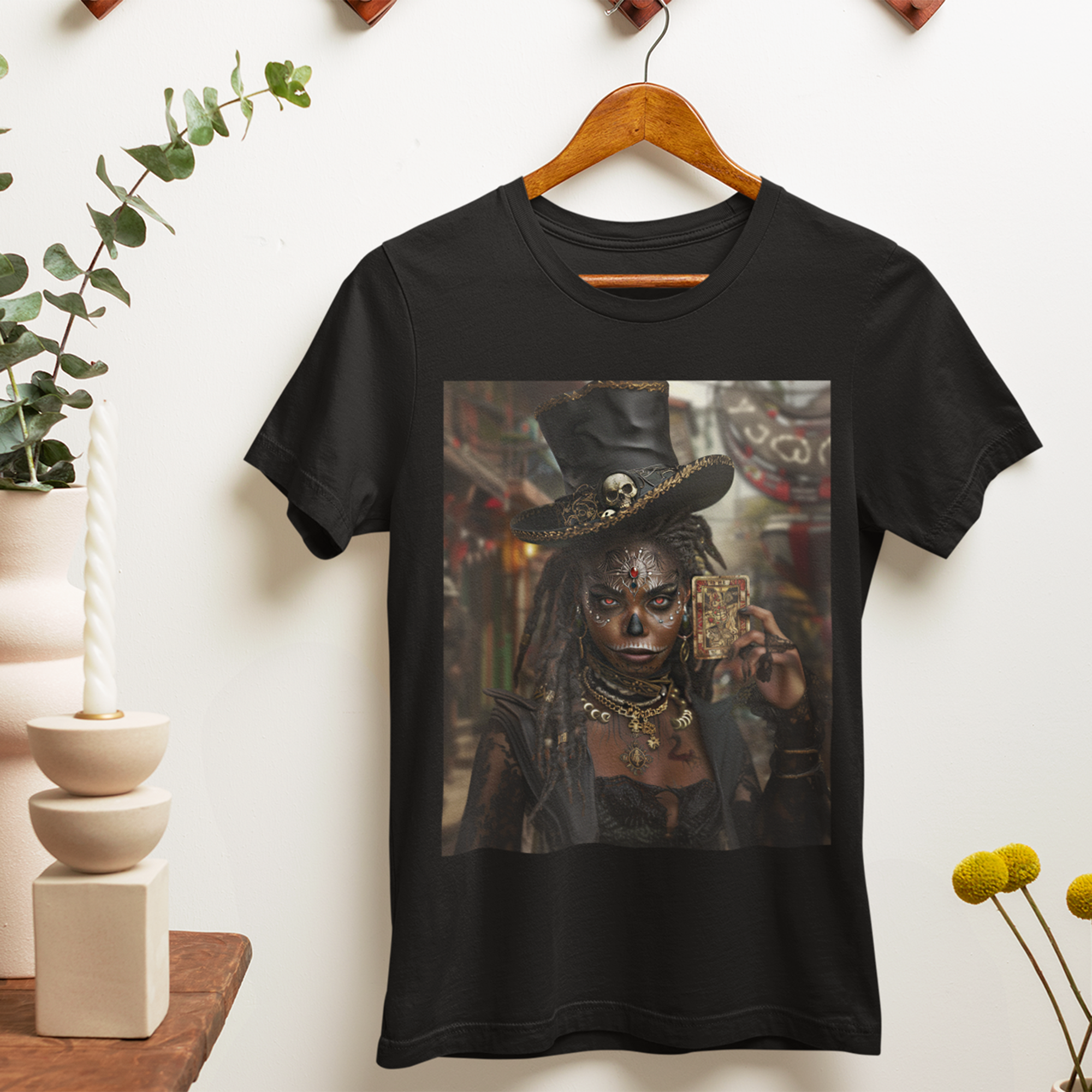 Voodoo Priestess Tee Shirt featuring Afrocentric gothic artwork of a woman with skull face paint, red eyes, and holding a tarot card. Dark fantasy Afrocentric graphic tee for mysticism, culture, and streetwear fashion.