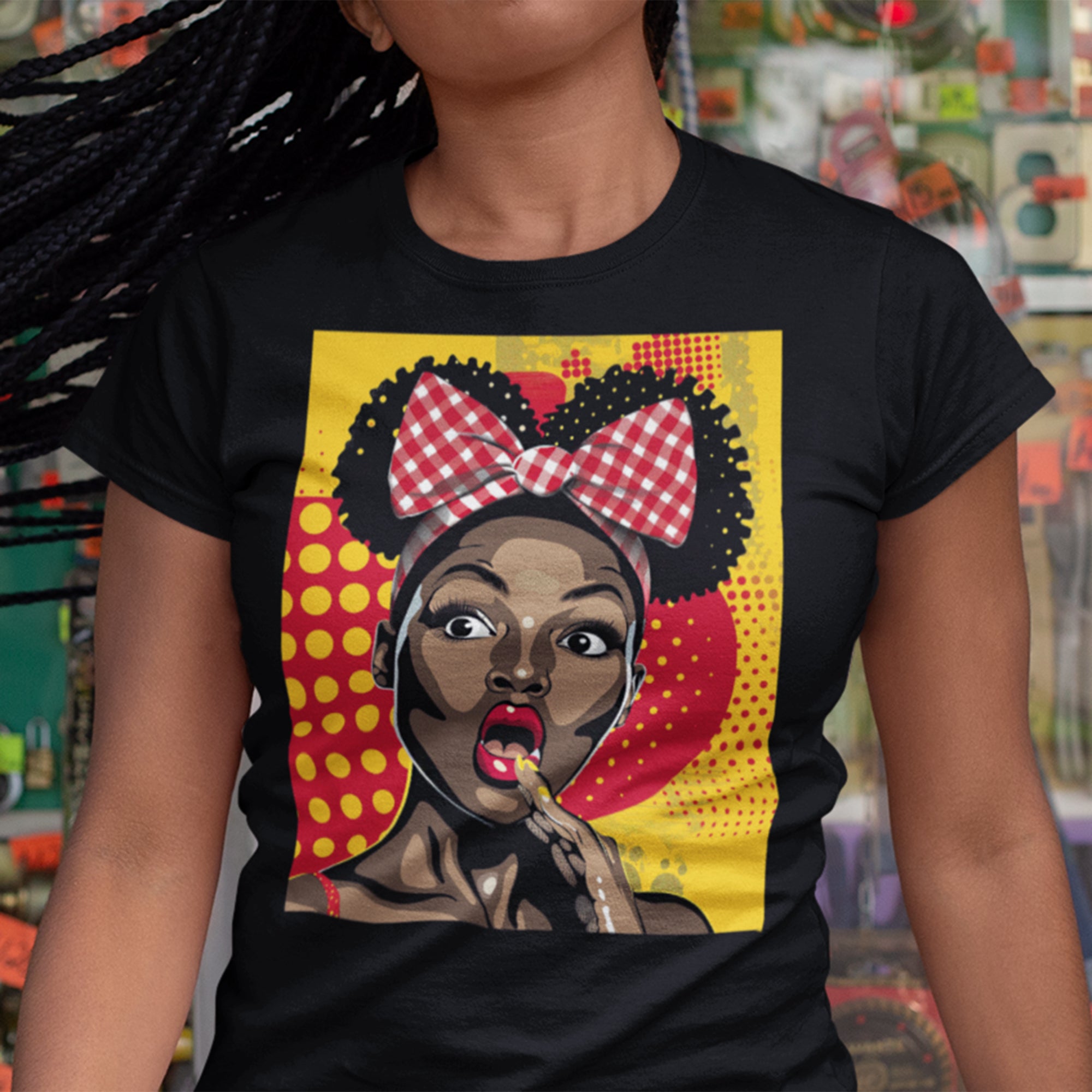 Black Girl Shocked Look Tee Shirt featuring a cartoon-style pop art illustration of a Black woman with natural hair and a red polka-dotted hair bow. Afrocentric graphic tee celebrating Black Girl Magic and expressive streetwear style.