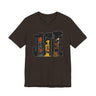 A dark brown short-sleeve crewneck t-shirt featuring a graphic print of the word 'JUSTICE' filled with stylized portraits of Black and African American faces in black, yellow, and orange.