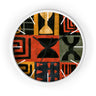 Black Afrocentric abstract geometric round wall clock with white time markings and white clock hands, featuring African-inspired symbols, spirals, arches, stripes, and graphic patterns in red, black, mustard gold, charcoal, and earthy gray, displayed against a white background.