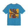 An aqua short-sleeve t-shirt featuring an Afrocentric Black woman with a large graphic print on the front with the word 'fabulous' in dark brown text over a collage of colorful objects.