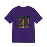 A purple short-sleeve crewneck t-shirt featuring a graphic print of the word 'JUSTICE' filled with stylized illustrations of faces in black, brown, and orange tones.