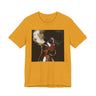 A mustard yellow short-sleeve crewneck t-shirt featuring a square graphic print of an abstract portrait of a Black woman with large hoop earrings on a black background.