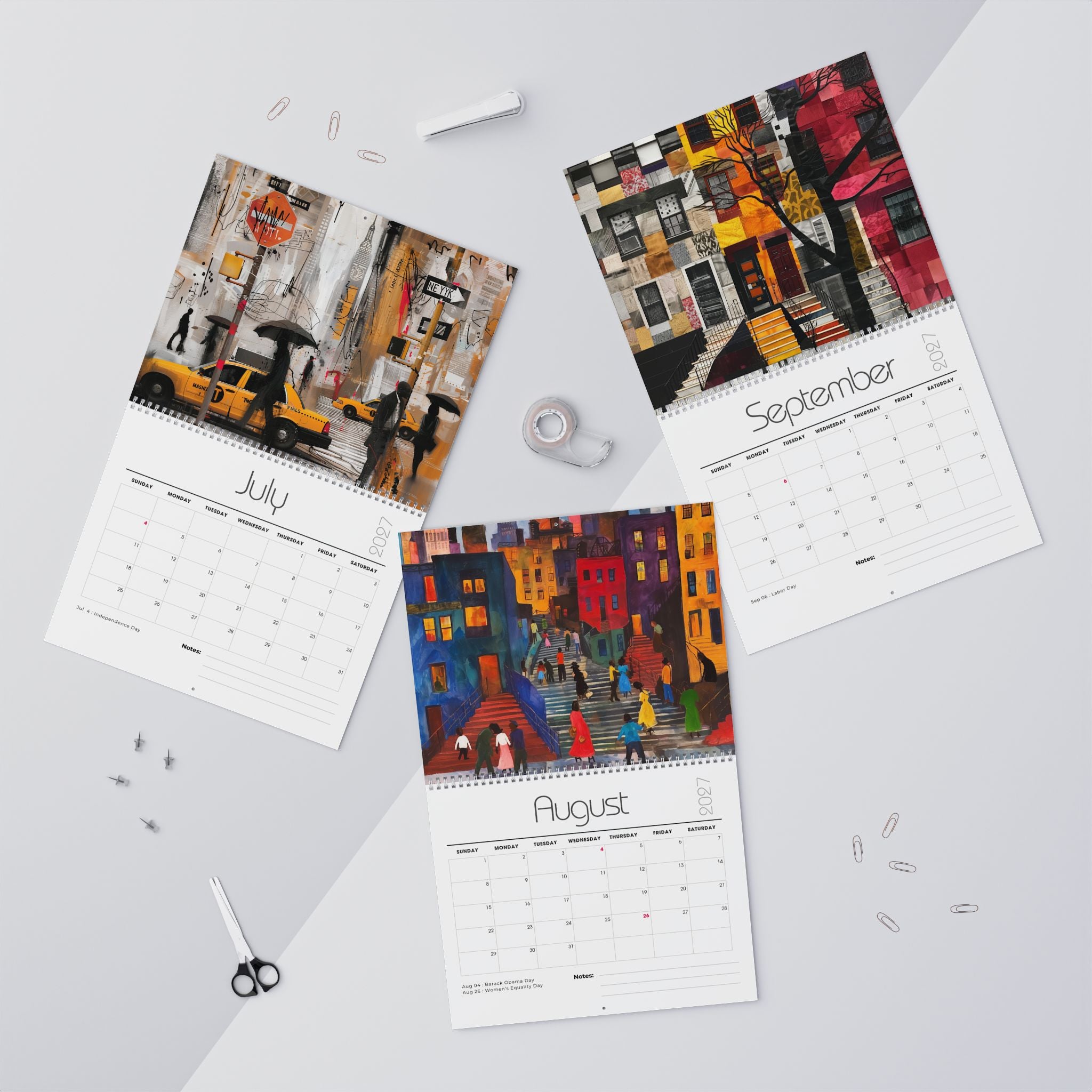 Three spiral-bound monthly calendars laid out on a light gray surface, each showing a colorful painted Harlem city street scene son the cover and a calendar grid page below. The visible months are July, August and September.