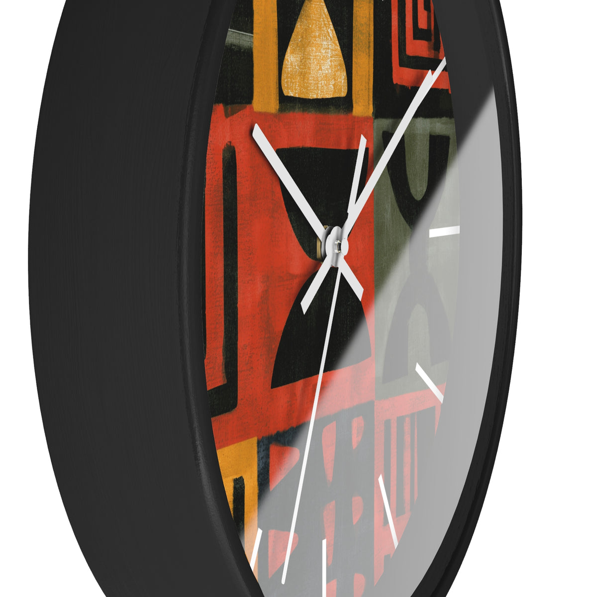 Black Afrocentric abstract geometric round wall clock with white time markings and white clock hands, featuring African-inspired symbols, spirals, arches, stripes, and graphic patterns in red, black, mustard gold, charcoal, and earthy gray, displayed against a white background.