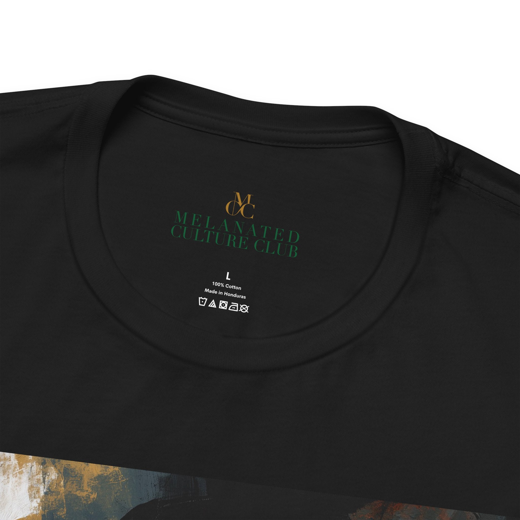 Close-up of a black short-sleeve t-shirt showing the inner neck print with the brand logo 'MCC and the text 'MELANATED CULTURE CLUB' in green, along with size and care label details.