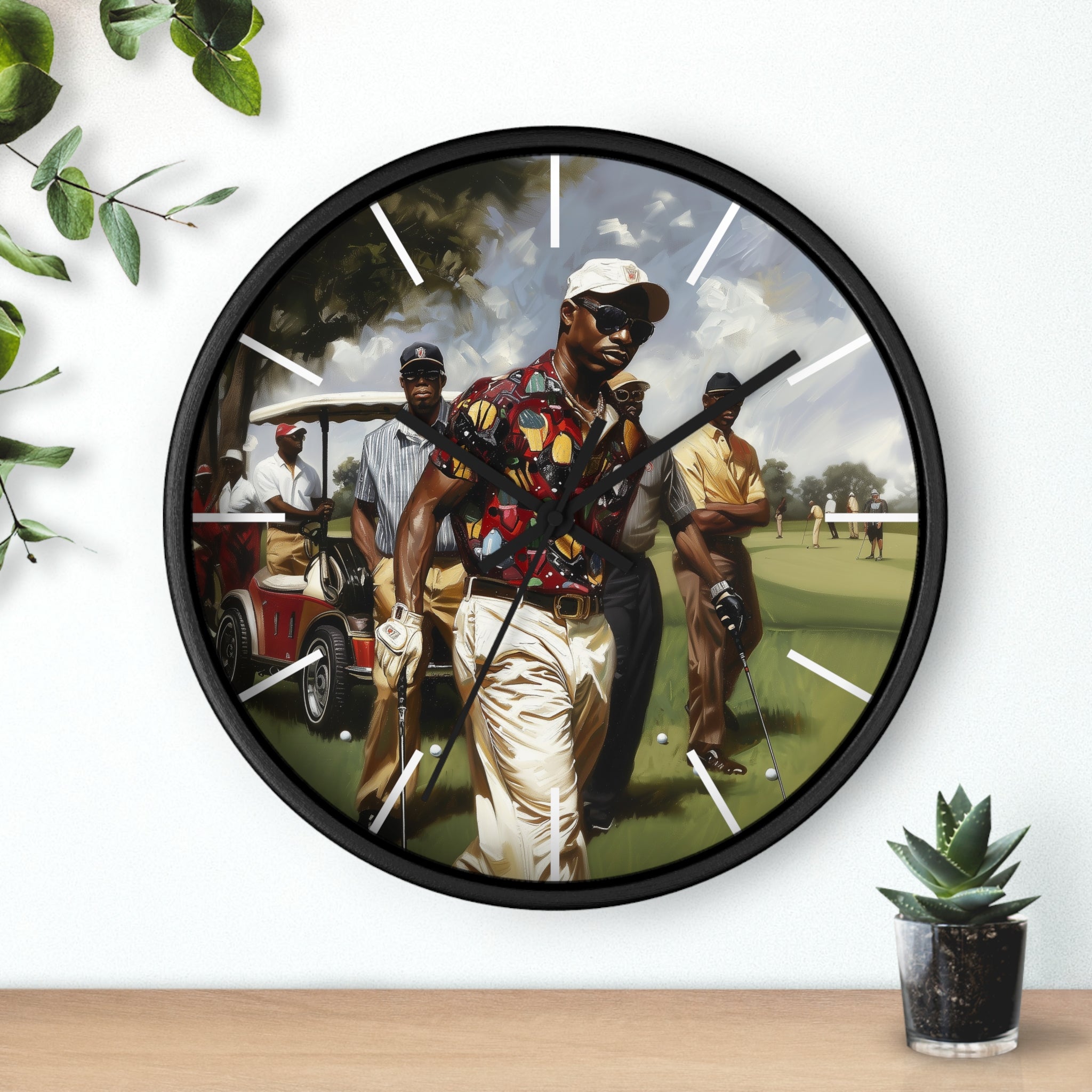 A round wall clock with a black frame and a printed golf-themed illustration on the face, mounted on a white wall above a wooden surface with small green plants nearby.