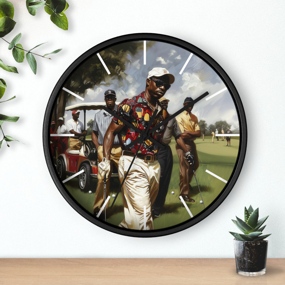A round wall clock with a black frame and a printed golf-themed illustration on the face, mounted on a white wall above a wooden surface with small green plants nearby.