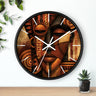 Black round wall clock with white time markings and white clock hands, featuring an abstract African-inspired mask face with geometric shapes, circular patterns, and textured details in terracotta, burnt orange, bronze, black, and warm gold tones, displayed against a white background with plant accessories.