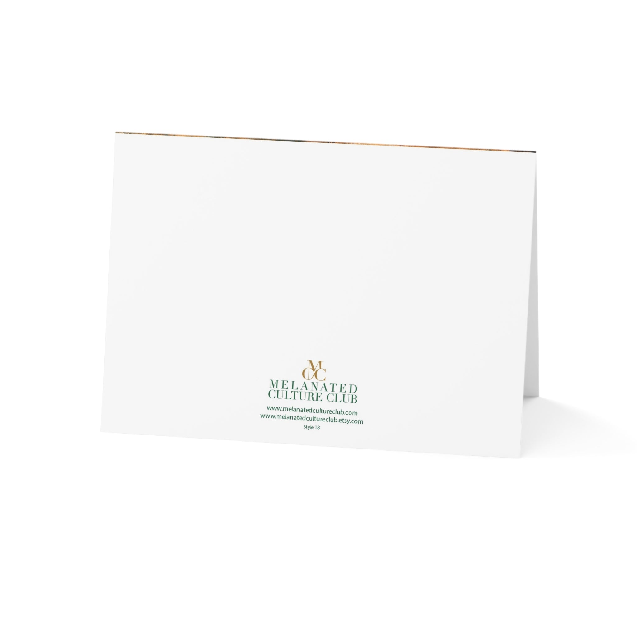 A white folded greeting card standing upright on a white background, printed with the Melanated Culture Club logo in green and gold near the bottom center.