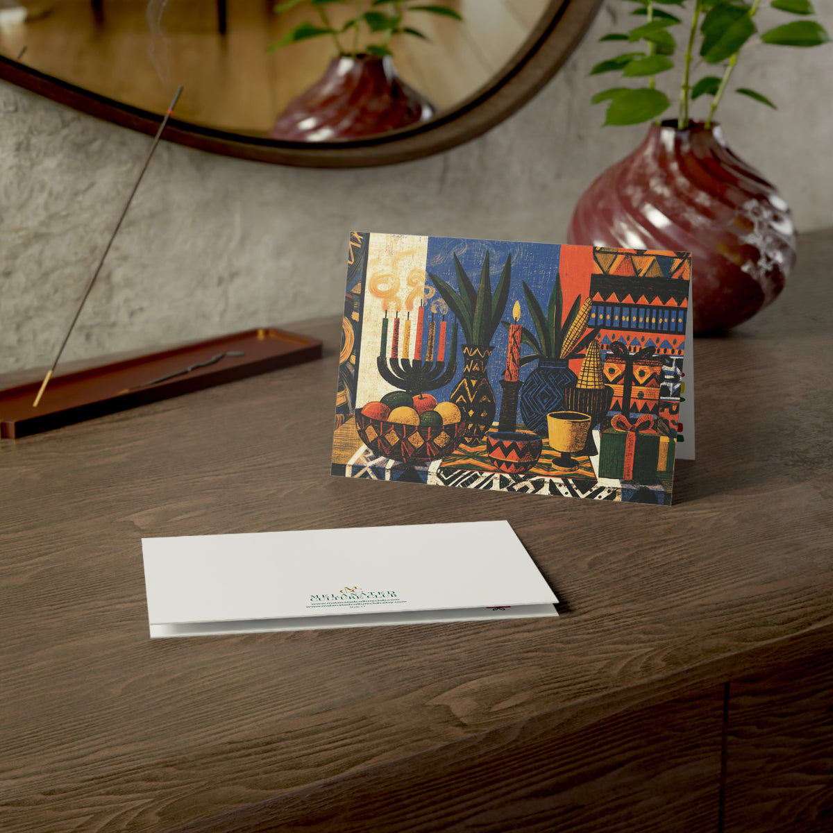 An Afrocentric Kwanzaa holiday greeting card celebrating Black heritage, African American culture, family, unity, community, and the Seven Principles of Kwanzaa, placed on a wood table.