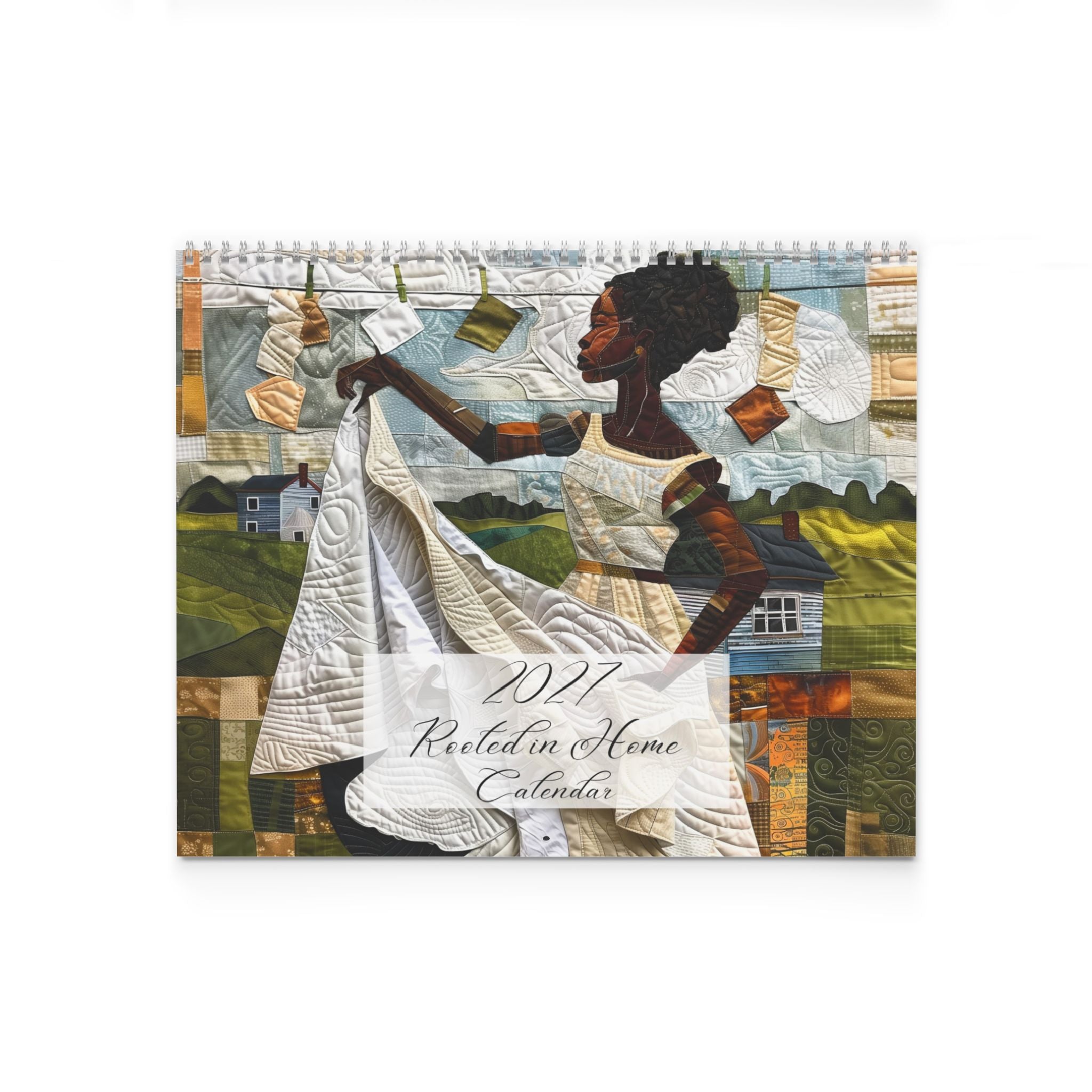 A spiral-bound 2027 wall calendar titled 'Rooted in Home Calendar' featuring a quilted-style illustration of a Black woman holding a white quilt, with a patchwork landscape and laundry hanging in the background, shown on a white background.