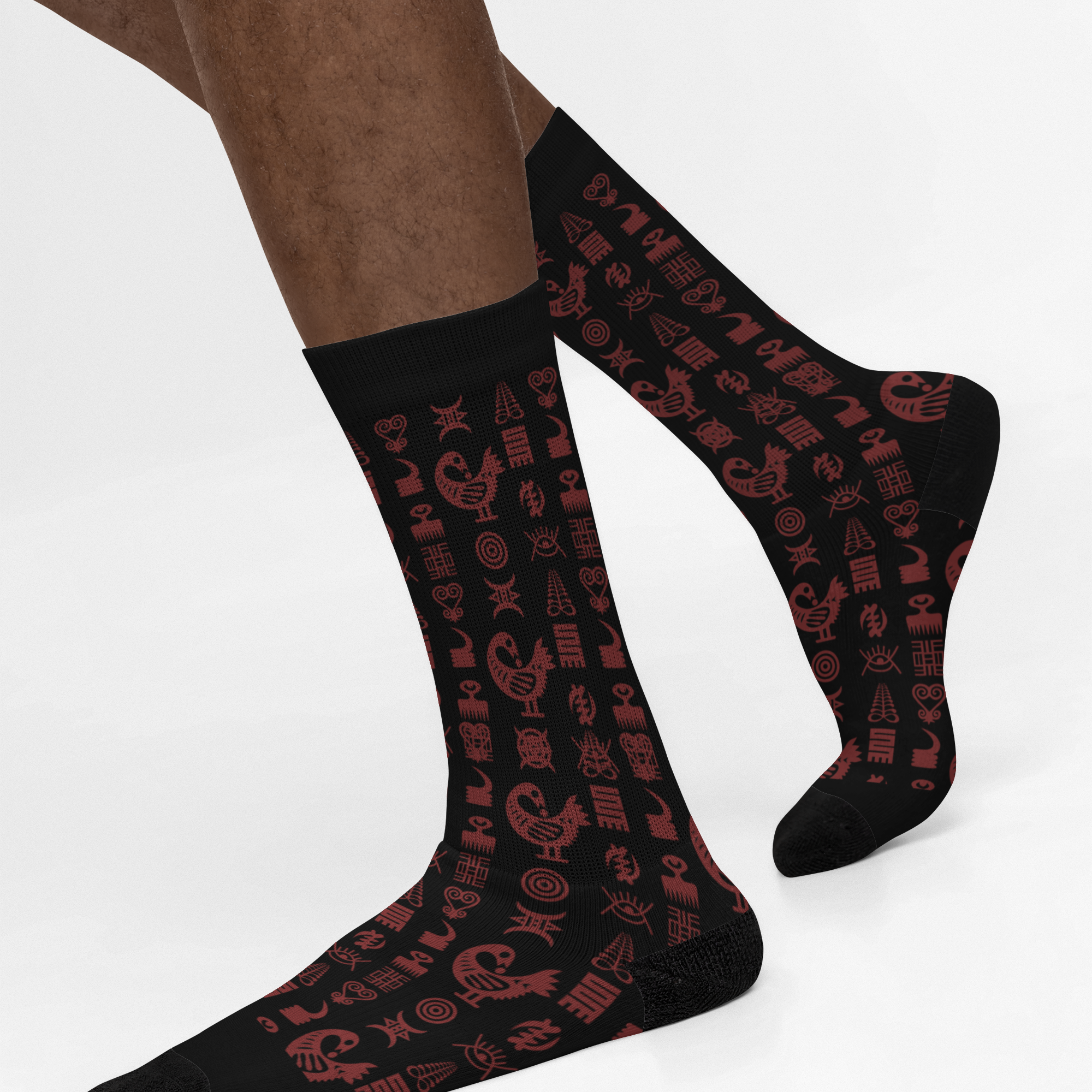 Crew socks featuring traditional Ghanaian Adinkra symbols in an Afrocentric pattern representing wisdom, strength, unity, perseverance, and African cultural heritage.