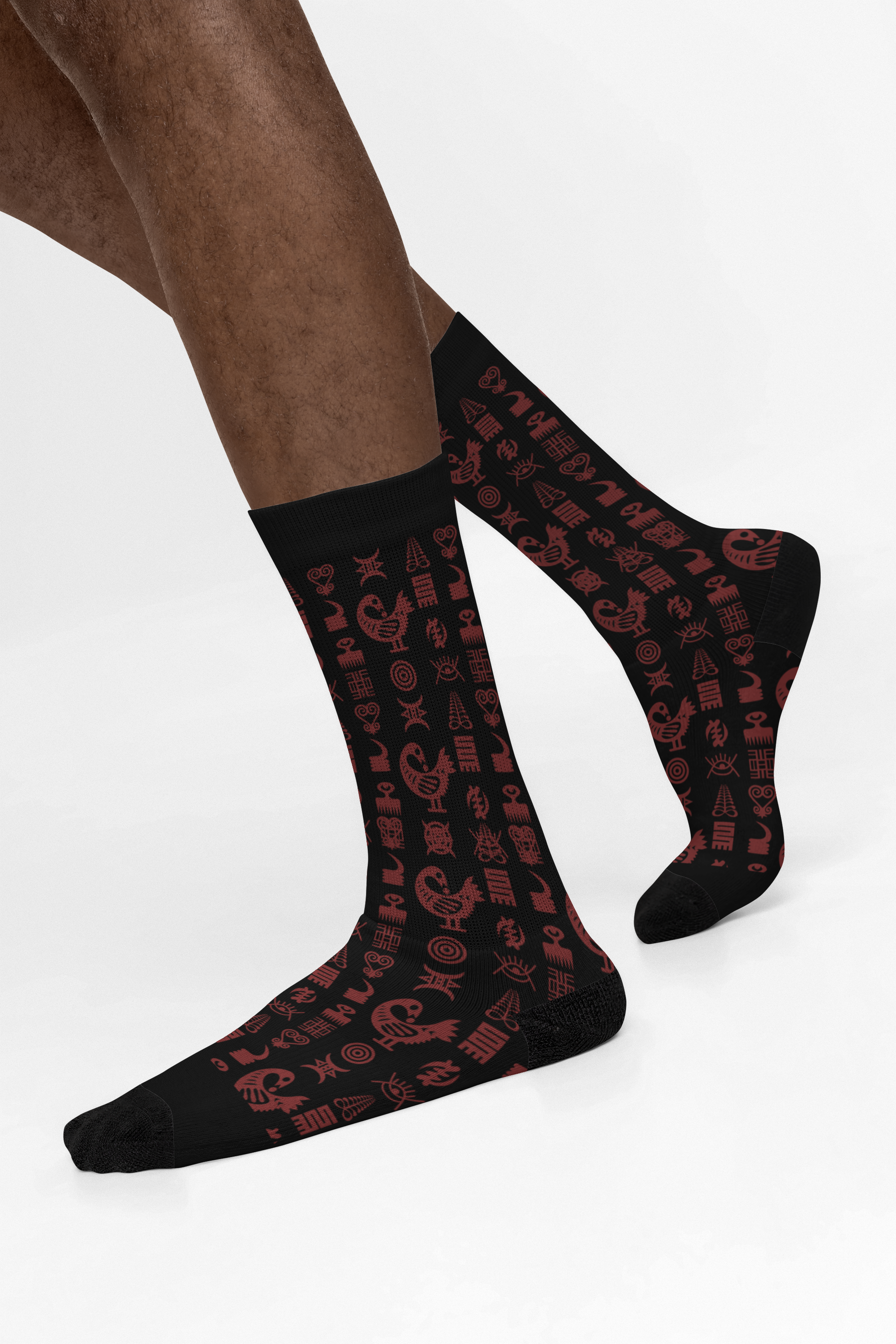 Crew socks featuring traditional Ghanaian Adinkra symbols in an Afrocentric pattern representing wisdom, strength, unity, perseverance, and African cultural heritage.
