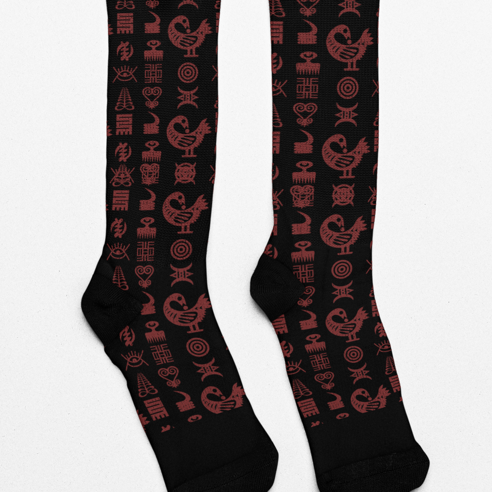 Crew socks featuring traditional Ghanaian Adinkra symbols in an Afrocentric pattern representing wisdom, strength, unity, perseverance, and African cultural heritage.