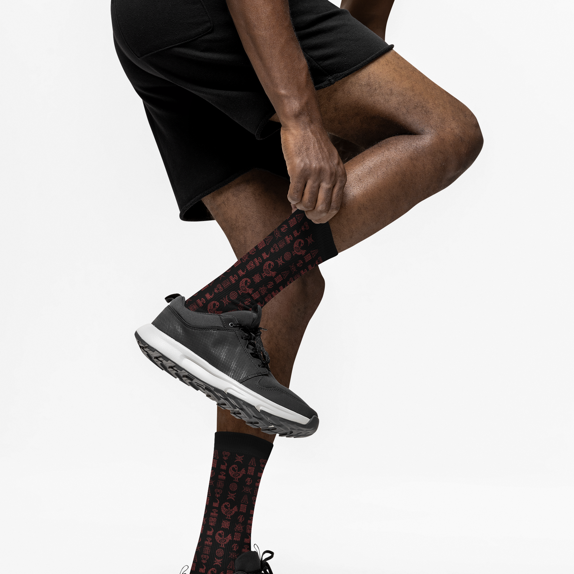 Crew socks featuring traditional Ghanaian Adinkra symbols in an Afrocentric pattern representing wisdom, strength, unity, perseverance, and African cultural heritage.