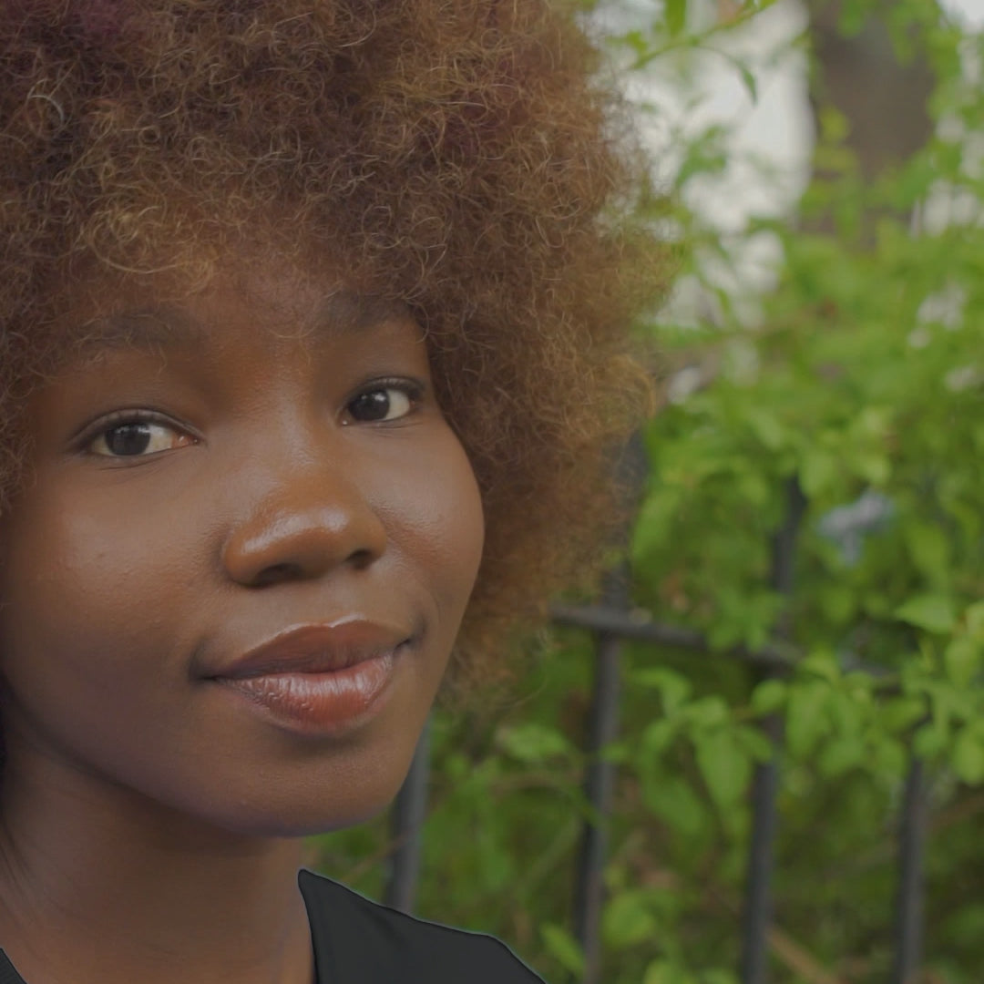 Video of Black young lady wearing the Boss Babe-Kendra tee shirt in black walking through a garden.