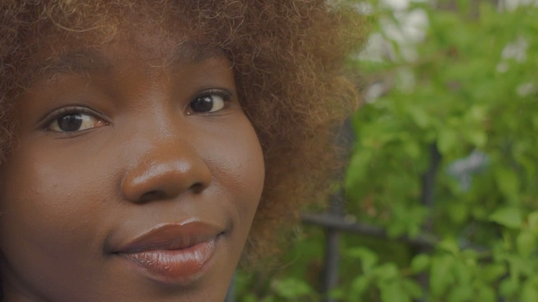 Video of Black young lady wearing the Boss Babe-Kendra tee shirt in black walking through a garden.