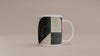 Video of 11 oz  Afrocentric geometric coffee mug featuring creme, black and red abstract shapes, arches, stripes and checkerboard patterns.