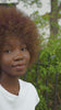 A video featuring a black young woman wearing a white tee shirt with the word "Justice" walking in the woods.  