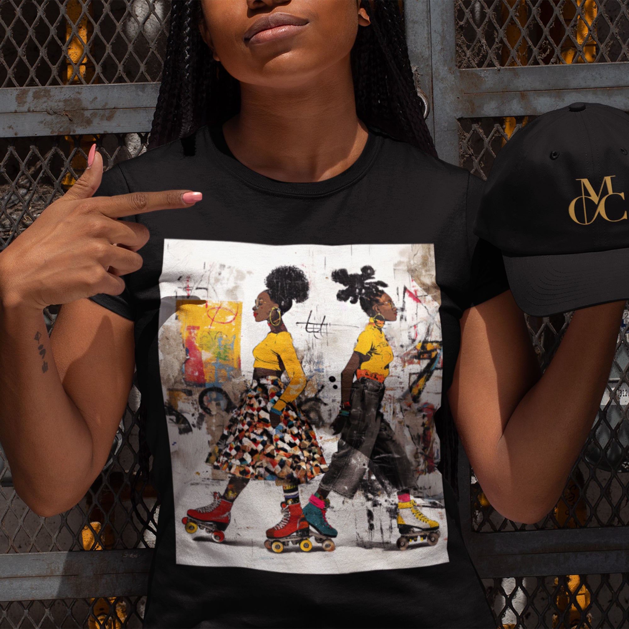 Two Black women with natural hairstyles wearing bold streetwear and roller skates, standing against a colorful abstract graffiti background on an Afrocentric graphic t-shirt.