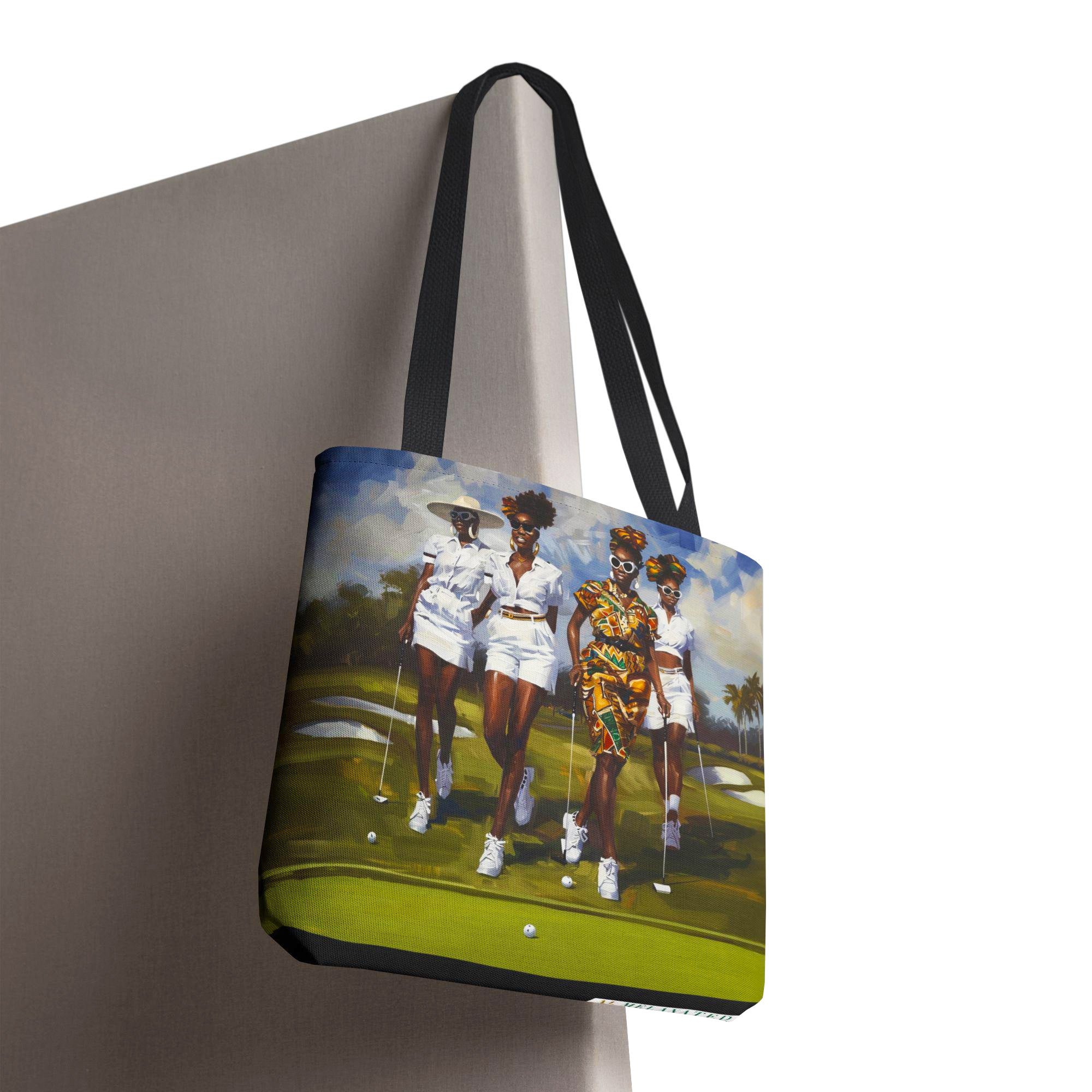 Afrocentric canvas tote bag featuring stylish Black women playing golf on a lush green golf course, celebrating leisure, sisterhood, strength, and team spirit.
