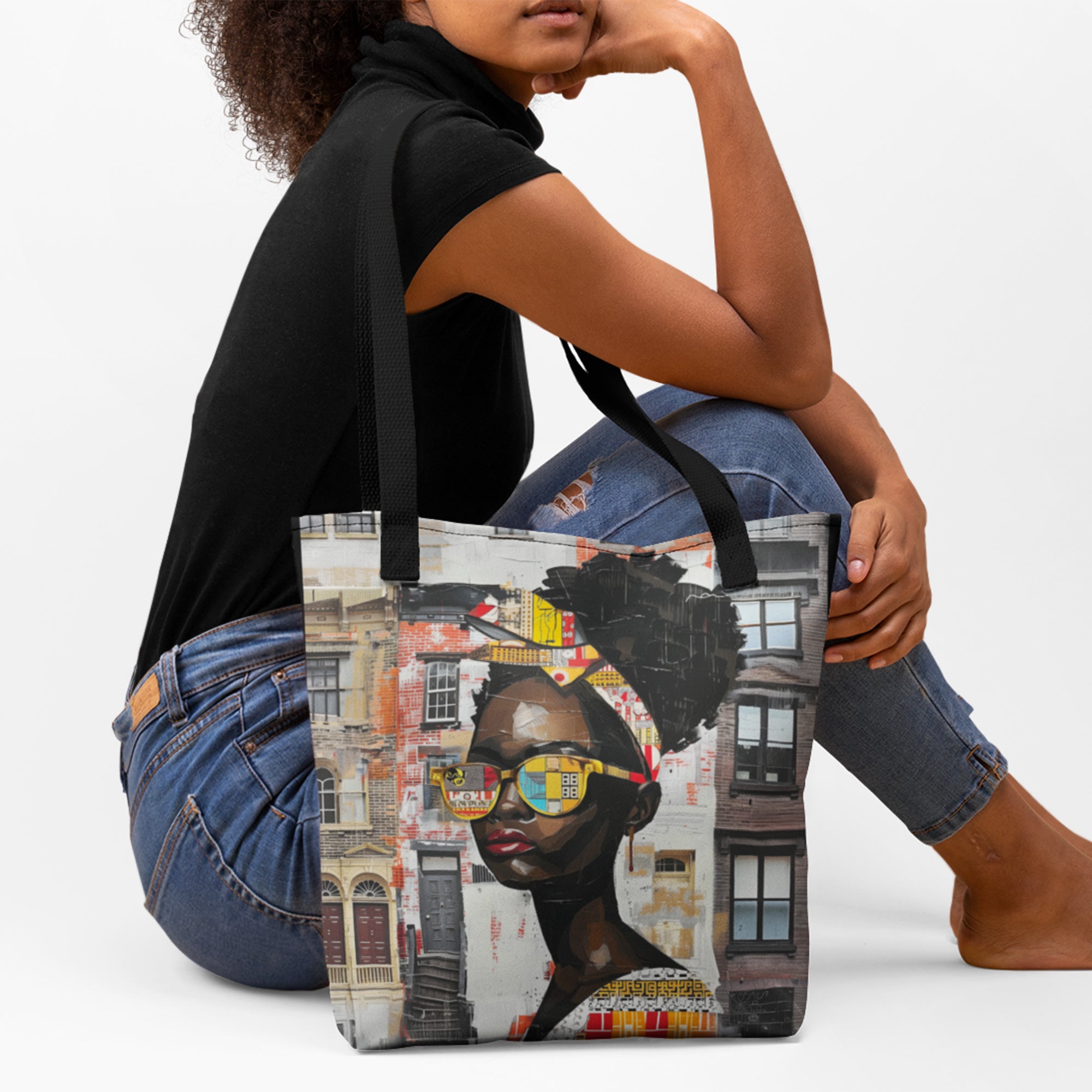 Female model sitting of floor, modeling carry-all tote bag featuring an abstract graffiti-style illustration of Boss Babe Kendra, styled against a white background.