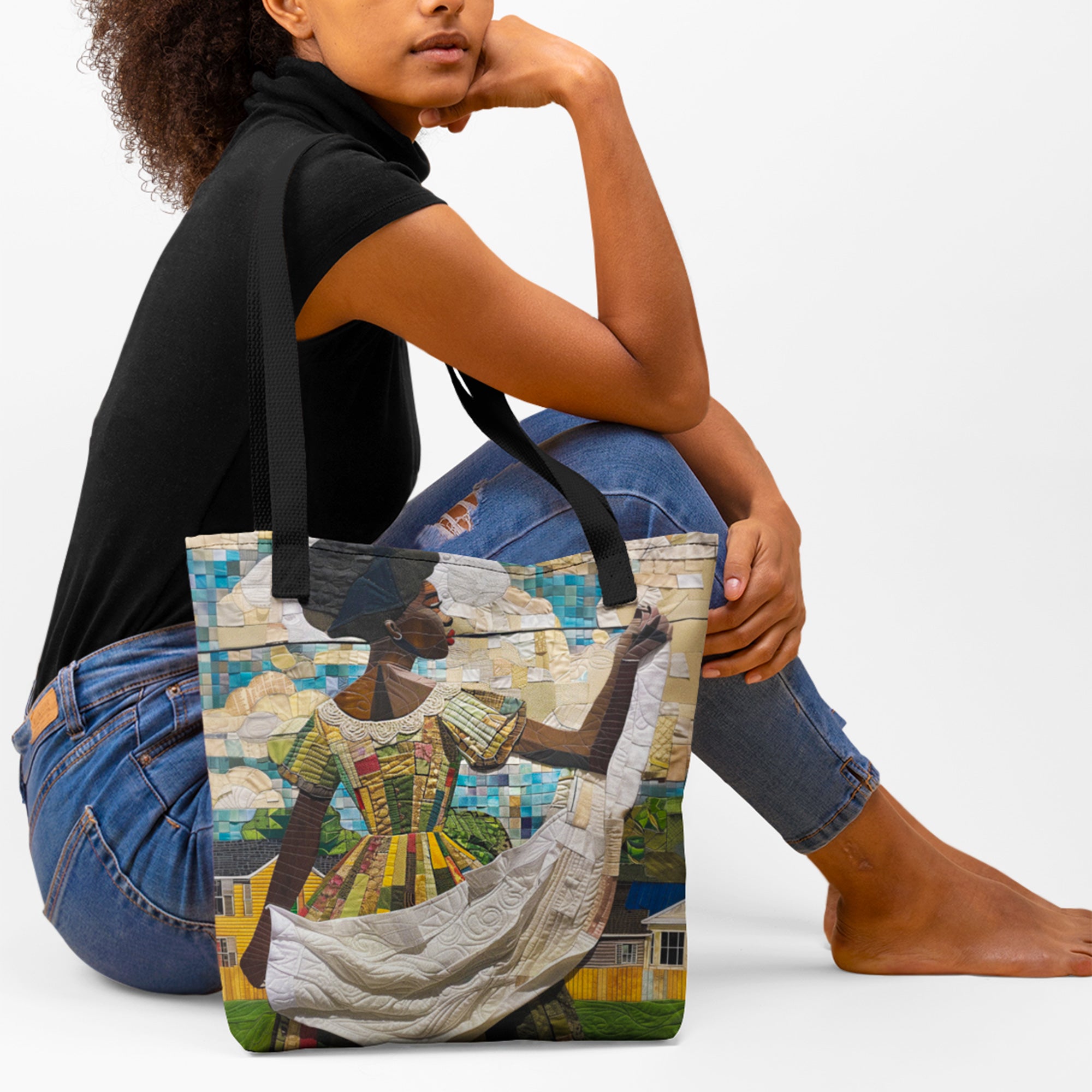 Model sitting on floor with tote bag featuring a Black woman hanging freshly washed sheets on an outdoor clothesline, created in a three-dimensional mosaic quilt collage style with flowing fabric and textured details.